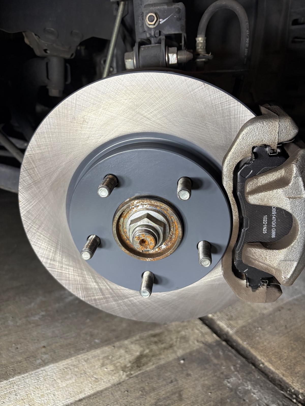 A new brake rotor and caliper fitted on a car